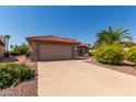 Tan house with terracotta roof and palm tree at 15631 W Bethesda Ct, Surprise, AZ 85374