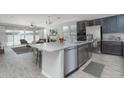 Modern kitchen with granite island, stainless steel appliances, and dark gray cabinetry at 16062 W Alameda Rd, Surprise, AZ 85387