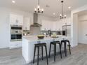 Modern kitchen with white cabinets, stainless steel appliances, and an island at 3758 W Moon Dust Trl, Queen Creek, AZ 85144