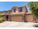 Two-story house with solar panels, three car garage, and landscaped front yard at 4506 W Maggie Dr, San Tan Valley, AZ 85144
