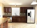 Kitchen with stainless steel appliances and dark wood cabinets at 21978 N Dietz Dr, Maricopa, AZ 85138