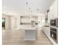 Modern kitchen with white cabinets, quartz countertops and island at 23997 N 172Nd Ave, Surprise, AZ 85387