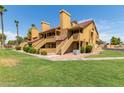 Attractive stucco condo building with grassy landscaping and palm trees at 4901 S Calle Los Cerros Dr # 267, Tempe, AZ 85282