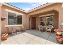 Covered courtyard entry with two wicker chairs and potted plants at 16205 W Berkeley Rd, Goodyear, AZ 85395