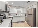 Modern kitchen with white cabinets, stainless steel appliances, and quartz countertops at 351 E Thomas Rd # D108, Phoenix, AZ 85012