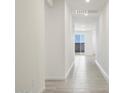 Bright hallway with tiled floors and a view of a backyard at 37287 W Patterson St, Maricopa, AZ 85138