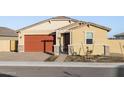 Tan house with orange garage door, landscaping, and walkway at 4642 N 177Th Ln, Goodyear, AZ 85395