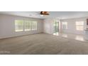 Spacious living room with large windows and ceiling fan at 17214 W Gibson Ln, Goodyear, AZ 85338
