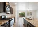 Modern kitchen with dark cabinets, granite countertops and island at 2084 N 214Th Dr, Buckeye, AZ 85396