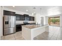Modern kitchen with dark cabinets, granite countertops, and stainless steel appliances at 2084 N 214Th Dr, Buckeye, AZ 85396