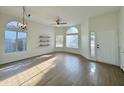 Bright living room with vinyl flooring, ceiling fan, and large windows at 4423 E Ponca St, Phoenix, AZ 85044