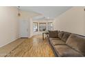 Living room with tile and wood flooring, couch, and home office area at 15890 W Diamond St, Goodyear, AZ 85338