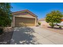Tan stucco house with a double-car garage and a small, landscaped front yard at 23780 W Tonto St, Buckeye, AZ 85326