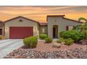 Single-story home with red garage door and landscaped front yard at 20285 N Winter Escape Ct, Maricopa, AZ 85138