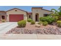 Single-story house with red garage door and landscaped yard at 20285 N Winter Escape Ct, Maricopa, AZ 85138