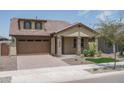 Tan house with a brown garage door and landscaping at 16172 W Alameda Rd, Surprise, AZ 85387