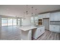 Open kitchen island with white cabinets and pendant lighting at 16172 W Alameda Rd, Surprise, AZ 85387