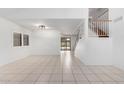 Spacious living room with tile floors and a view into the kitchen and stairs at 2605 N 89Th Dr, Phoenix, AZ 85037