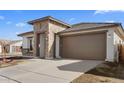 New construction home with stone and stucco exterior, and a two-car garage at 7245 S 75Th Dr, Laveen, AZ 85339