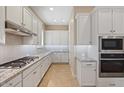 Bright kitchen with white cabinets, granite countertops and gas cooktop at 25807 N 19Th Gln, Phoenix, AZ 85085