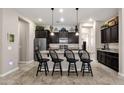 Island kitchen with granite countertops and dark cabinets at 2126 W Red Fox Rd, Phoenix, AZ 85085
