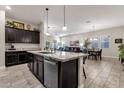 Open kitchen with granite island, dark cabinets and views to Gathering room at 2126 W Red Fox Rd, Phoenix, AZ 85085