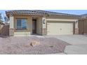 Tan house with a two-car garage and drought-tolerant landscaping at 11519 W Deanne Dr, Youngtown, AZ 85363