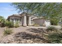 Single-story home with desert landscaping and a two-car garage at 13164 W Ocotillo Ln, Surprise, AZ 85374