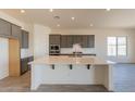 Modern kitchen with large island and gray cabinets at 18938 W Ocotillo Rd, Waddell, AZ 85355