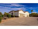 Three-car garage with a desert landscape and a palm tree at 30009 N 58Th St, Cave Creek, AZ 85331