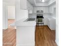 Bright eat-in kitchen, featuring white cabinetry, stainless steel appliances, and wood flooring at 4730 W Northern Ave # 3067, Glendale, AZ 85301