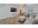 Living room with beige sofas, tiled floors, and a large TV at 2343 E Meadow Land Dr, San Tan Valley, AZ 85140