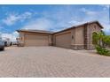 Three-car garage with paver driveway and stone accents at 35140 N 52Nd Pl, Cave Creek, AZ 85331