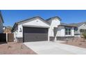 One-story home with a gray garage door, stone accents and landscaping at 6754 W Andrea Dr, Peoria, AZ 85383