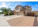 Two-story house with a three-car garage and a brick paved driveway at 5116 W Trotter Trl, Phoenix, AZ 85083