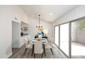 Modern dining room with glass table and access to backyard at 916 S Melody Ln, Tempe, AZ 85281
