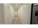 Light hallway with wood-look flooring at 46137 W Starlight Dr, Maricopa, AZ 85139