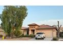 Tan house with tile roof, two-car garage, and landscaping at 46137 W Starlight Dr, Maricopa, AZ 85139