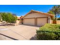 View of the house's exterior, three-car garage, and landscaping at 947 W Barcelona Dr, Gilbert, AZ 85233