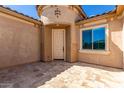 Exterior front entry with a light beige door and stone flooring at 26496 W Lone Cactus Dr, Buckeye, AZ 85396