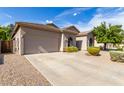 Tan one story home with a landscaped yard and driveway at 43502 W Kramer Ln, Maricopa, AZ 85138