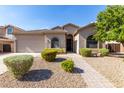 Tan one-story home with a landscaped yard and walkway at 43502 W Kramer Ln, Maricopa, AZ 85138