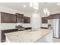 Modern kitchen with granite island and stainless steel appliances at 40143 W Curtis Way, Maricopa, AZ 85138