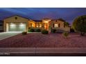 One story home with a two car garage at dusk at 12840 W Santa Ynez Dr, Sun City West, AZ 85375