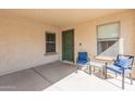 Inviting front porch with two blue chairs and a small table at 40350 W Art Pl, Maricopa, AZ 85138
