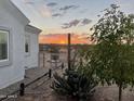 Landscaped backyard with sunset view and desert plants at 23208 W Gloria Ln, Wittmann, AZ 85361