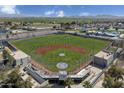 Aerial view showcasing a baseball field with bleachers and surrounding landscape at 5753 S 243Rd Dr, Buckeye, AZ 85326