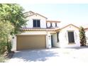 Two-story house with tan siding, brown garage door, and landscaping at 36181 W Olivo St, Maricopa, AZ 85138