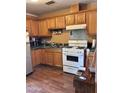 Galley kitchen with wood cabinets and appliances at 6321 N 65Th Dr, Glendale, AZ 85301