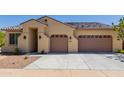 Tan house with a three-car garage and desert landscaping at 707 W Coles Rd, Phoenix, AZ 85041